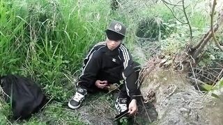 Cute Oriental homosexual twink in a ebony-and-white adidas tracksuit and Campus sneakers masturbates and cums outdoors