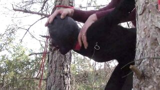 Bound up to a tree outdoor on hawt garments, wearing hose and high ankle boots heels, coarse screw