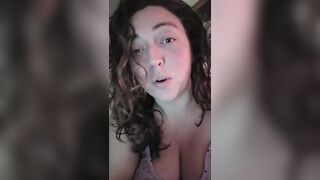 big beautiful woman lets her large breasts hang whilst water oozes down from 'em