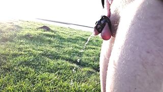 Desperately peeing in chastity cage by lake