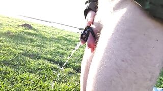 Desperately peeing in chastity cage by lake