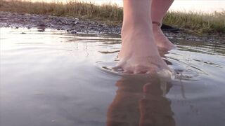 Light-colored tights and beach shoes in the puddle