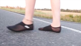 Light-colored tights and beach shoes in the puddle
