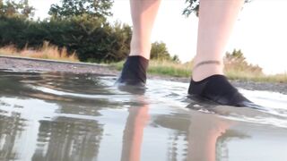 Light-colored tights and beach shoes in the puddle