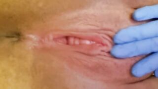 A beauty nurse in gloves bangs herself and shows her body