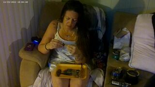 Breasty beauty in pink brassiere and pants smokin' and playing movie games