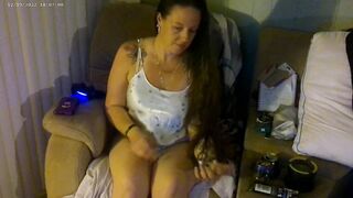 Breasty beauty in pink brassiere and pants smokin' and playing movie games