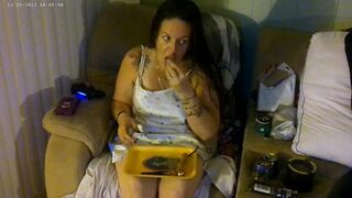 Breasty beauty in pink brassiere and pants smokin' and playing movie games