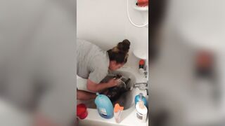 Charming gal gives kitten a washroom