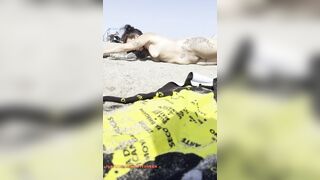 Stripped gal playing in the sand?