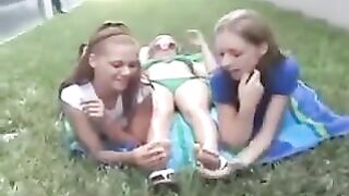 Three girls worshipping each other's feet outside