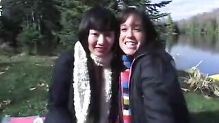 Two young lesbians play with a double ended dildo outdoors
