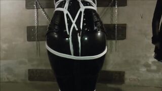 Cat Woman is wearing her sexy, latex costume while being tied up and tortured by two ladies