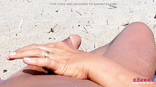 She shows her ass on the beach of Cap d'Agde and jerks off her pussy and then her boyfriend's cock with voyeurs