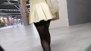 A girl walks in a short skirt without panties in a shopping mall