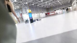 A girl walks in a short skirt without panties in a shopping mall