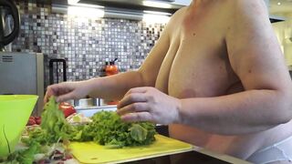 Housewife with large saggy melons crumbles salad in the kitchen.