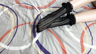 Caressing lengthy legs of angel in ebony lace socks