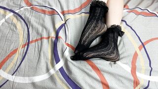 Caressing lengthy legs of angel in ebony lace socks