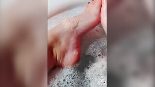 Sexy golden-haired massaging her soaked soapy feet in the baths