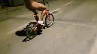 Hot chap disrobes on a public street and rides a bike nude touching his weenie - risky