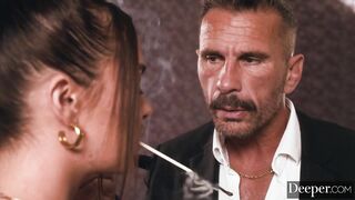 A cigar shop employee is at the service of an exacting customer.