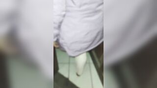 Aged woman wearing red thread in transparent leggings, captured on the street