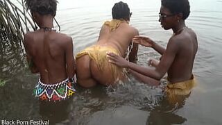 Raw documentary footages with three Afro tribe gals dancing in the river in the forrest