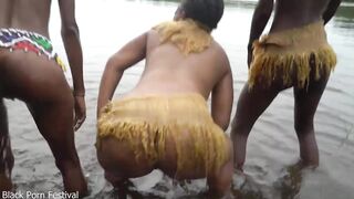 Raw documentary footages with three Afro tribe gals dancing in the river in the forrest