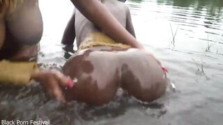Raw documentary footages with three Afro tribe gals dancing in the river in the forrest