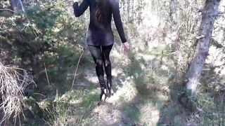 Walking on the wood wearing a ebony suit, hose and high heels ankle boots
