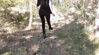 Walking on the wood wearing a ebony suit, hose and high heels ankle boots