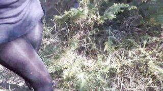 Walking on the wood wearing a ebony suit, hose and high heels ankle boots