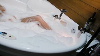 Красивая блондинка принимает ванну и ласкает грудь