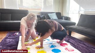 Cute lesbian babes using a sex tool after playing a disrobe twister game in the living room