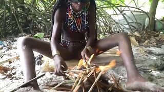 Pretty tribe beauty making traditional jewelery next to a firecamp