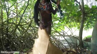 Pretty tribe beauty making traditional jewelery next to a firecamp