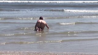 Floozy flashing booty and snatch at beach
