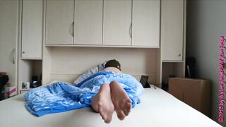 Füße in Strumpfhose und Maske im Bett
